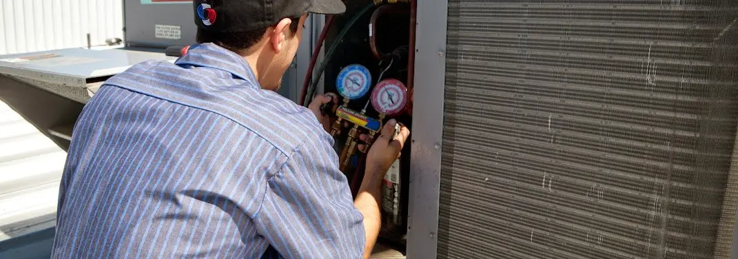 HVAC technician servicing a condenser unit in Mililani Town