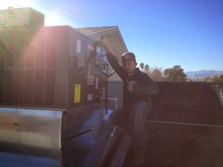 HVAC technician performing Boiler Repair on a rooftop unit in Mililani Town